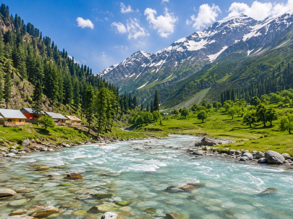 Turquoise river flowing through green meadows in Naran Valley